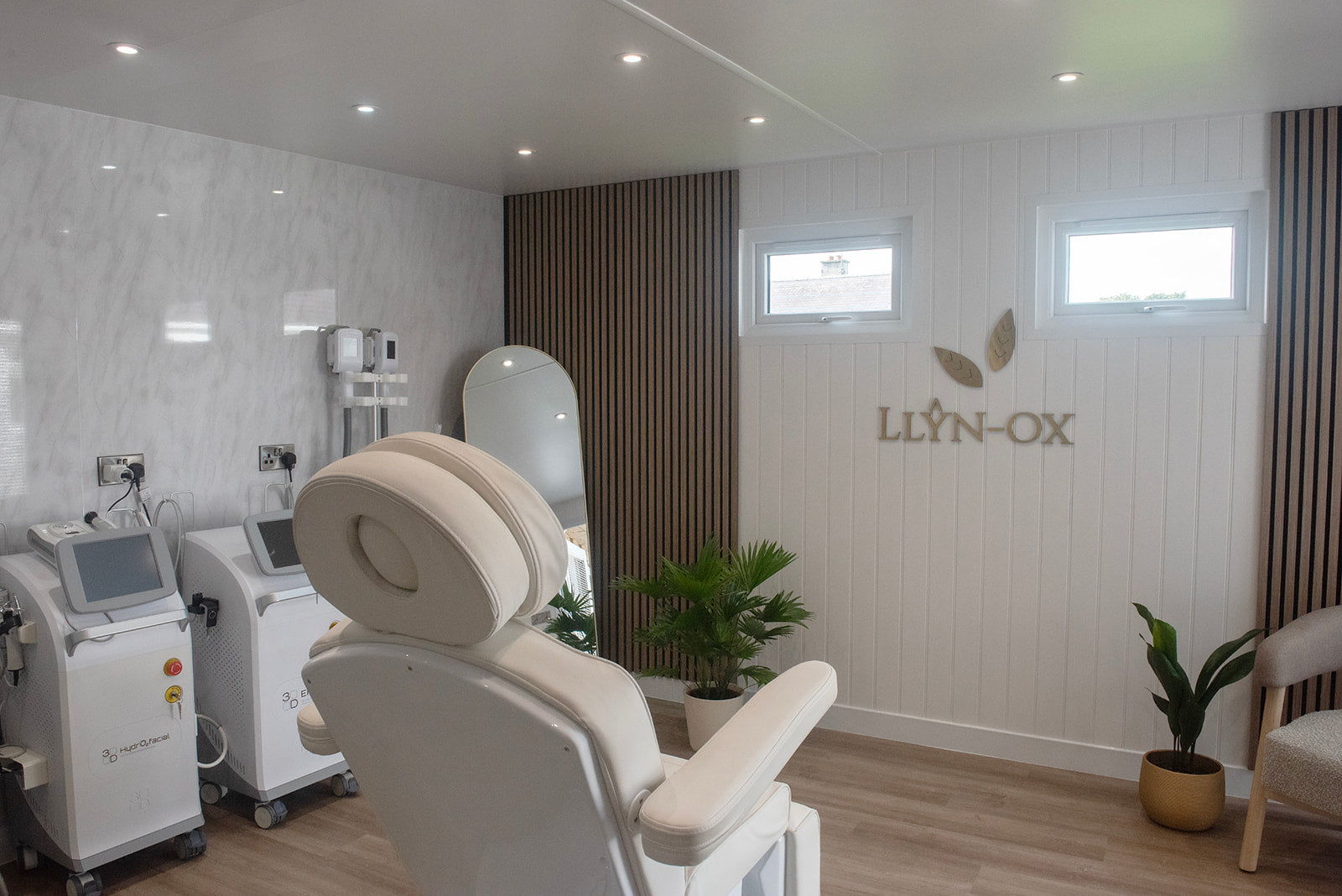 Modern aesthetics salon interior with Llyn-Ox branding on the wall.