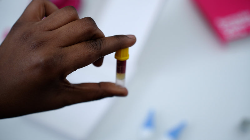 Hand holding a blood sample vial with a blurred background